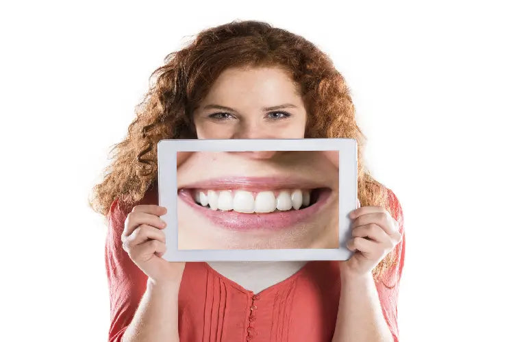 Une image d'une fille tenant une image agrandie de ses dents