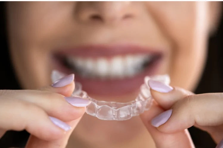 Une femme appliquant des aligneurs transparents la nuit