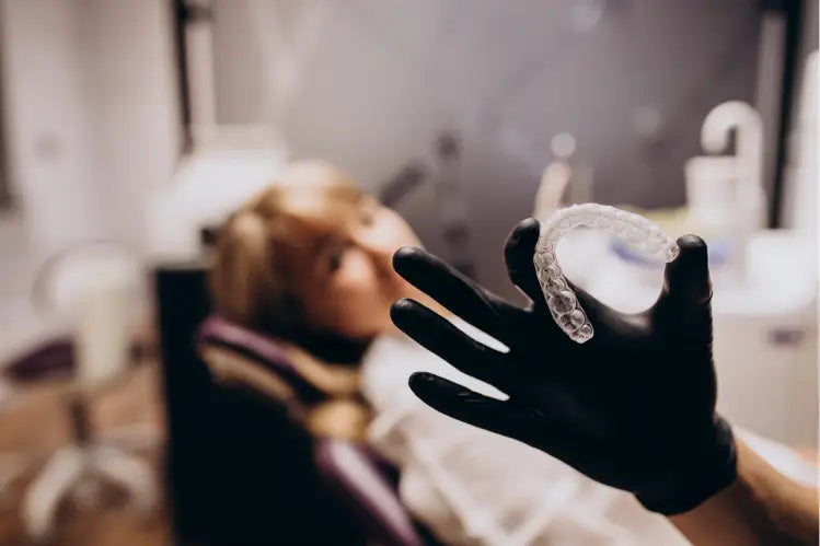 Une personne tenant un aligneur transparent