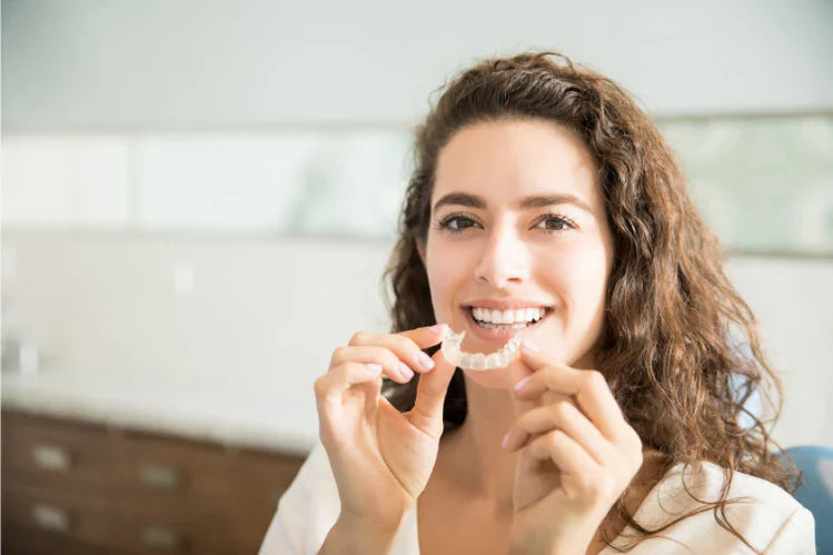 Une femme souriante en mettant son appareil de contention transparent