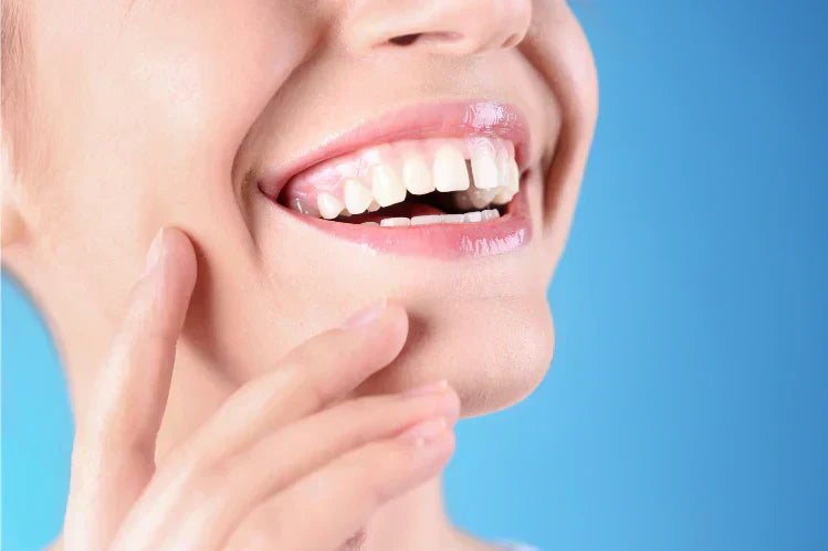 Une femme souriante avec un espace entre ses dents de devant.