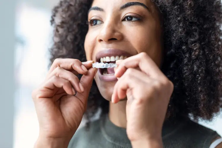  A woman applying invisible aligners