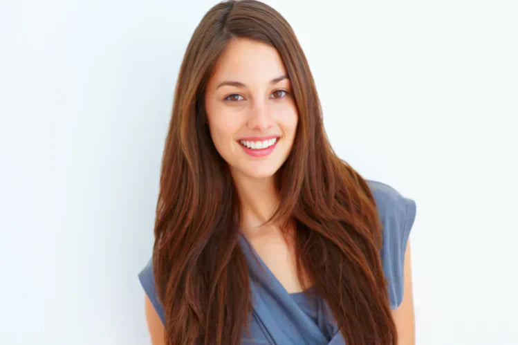 Une jeune fille souriante pour montrer ses dents droites.