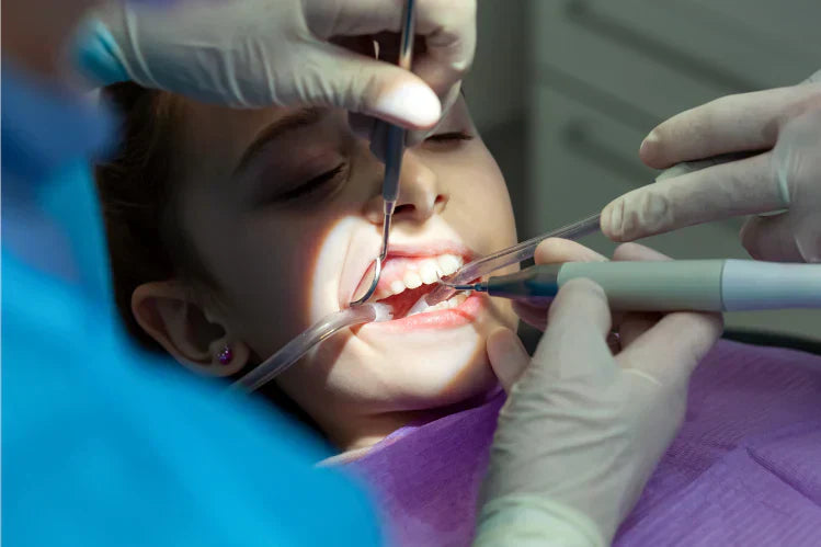 Une jeune fille se fait soigner les dents dans un cabinet dentaire.